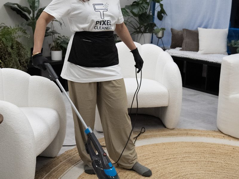 Professional cleaner vacuuming living room