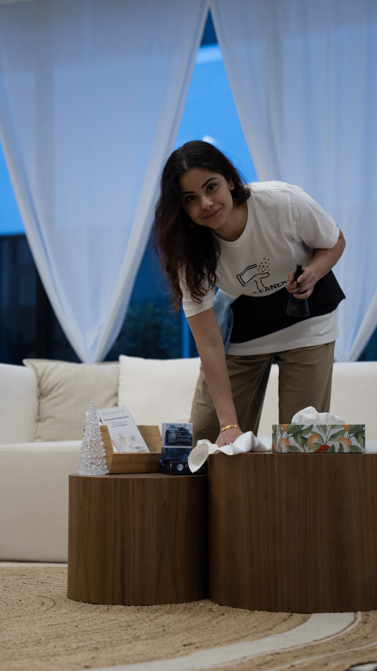 Professional cleaner wiping coffee table in Vancouver home - standard cleaning service